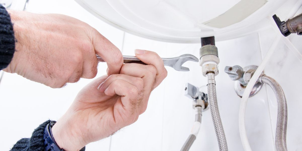 A skilled plumber fixing a leaky faucet, symbolizing the expertise and guidance offered by MapPlumber.com in their comprehensive plumbing guide.